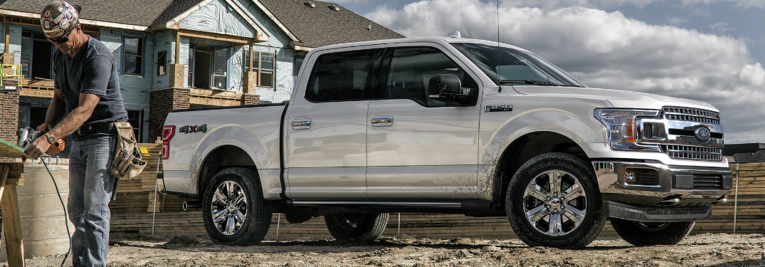A construction worker standing near a white 2020 Ford F-150