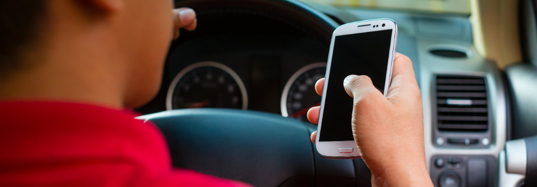 man holding phone while driving