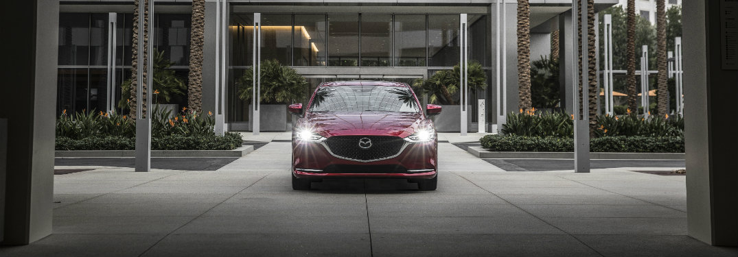 dark red mazda6 with headlights on