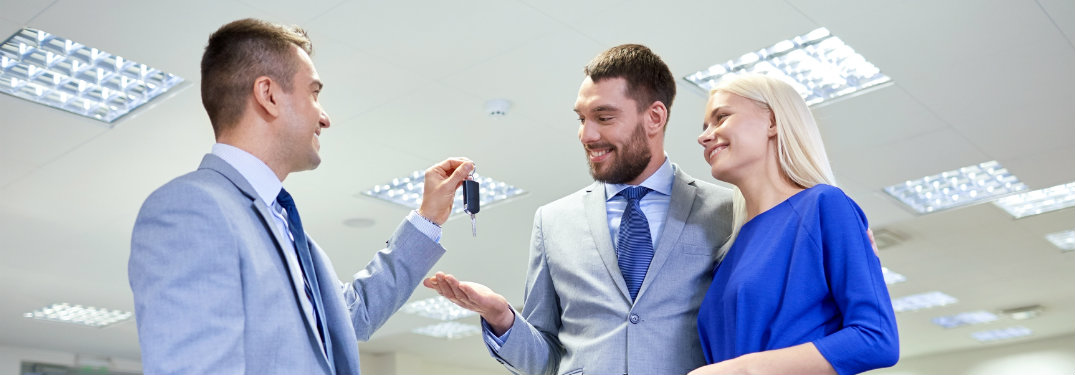 man giving keys to couple