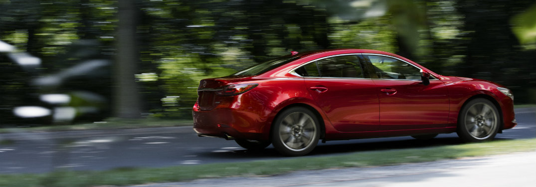 red mazda6 driving fast by trees