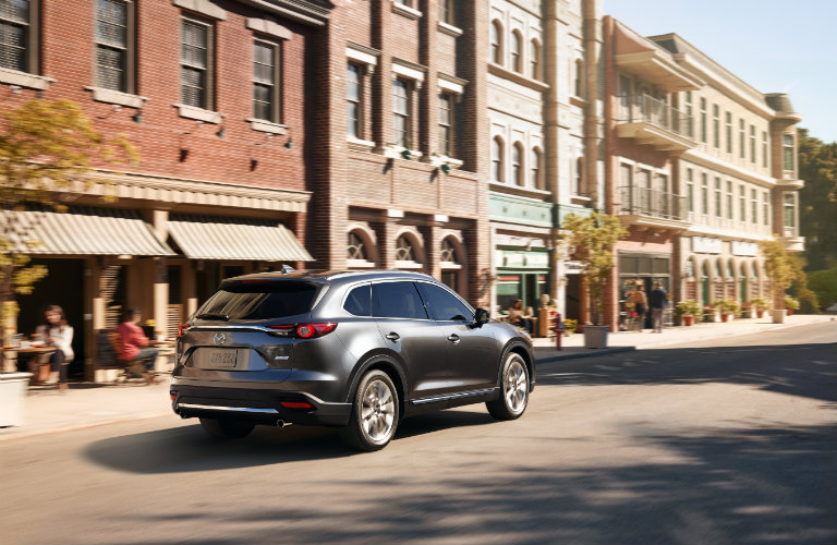 rear of dark gray mazda cx-9 on city street