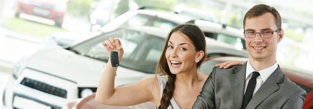 woman holding keys smiling next to man