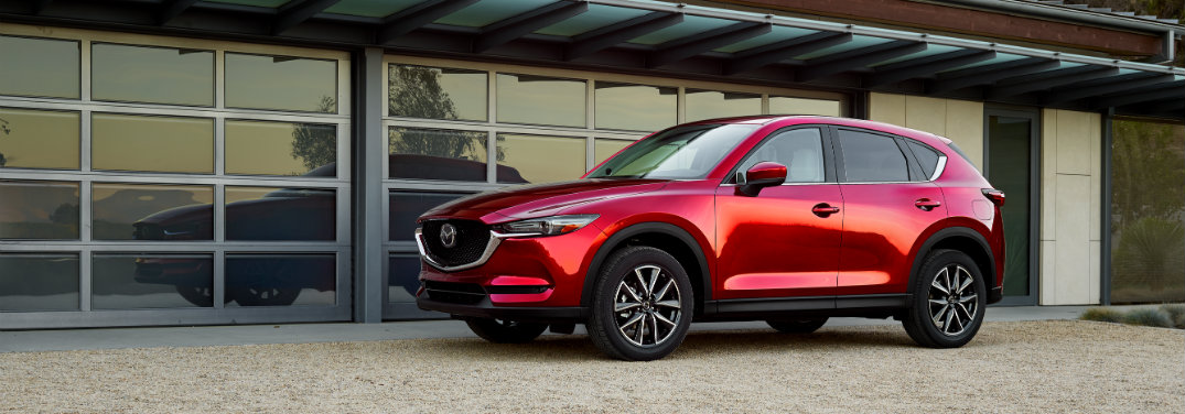 left side of red mazda cx-5 parked in front of garage