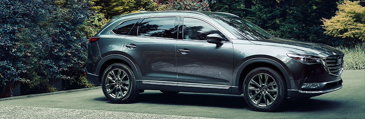A gray 2020 Mazda CX-9 parked along a woodland road.