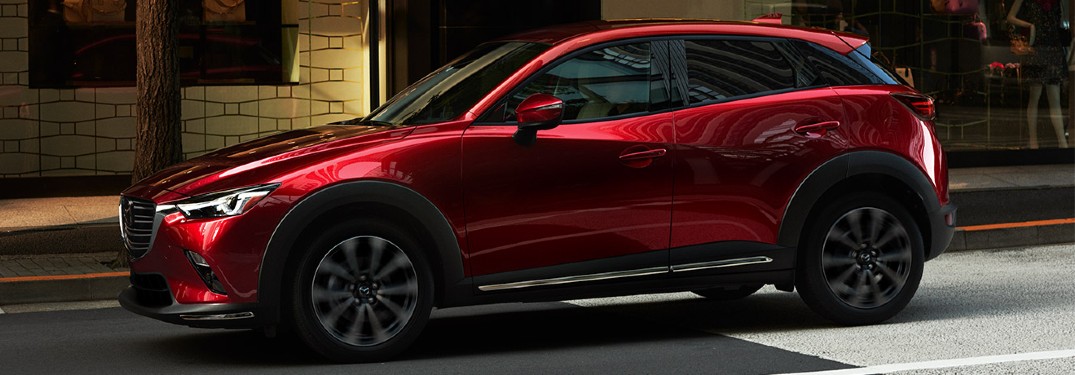 A red 2019 Mazda CX-3 stopped at an intersection in the city.