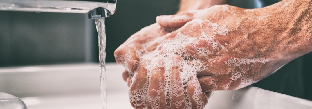 A person washing their hands with soap and water.
