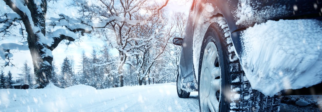 A vehicle driving on a snow-covered street.