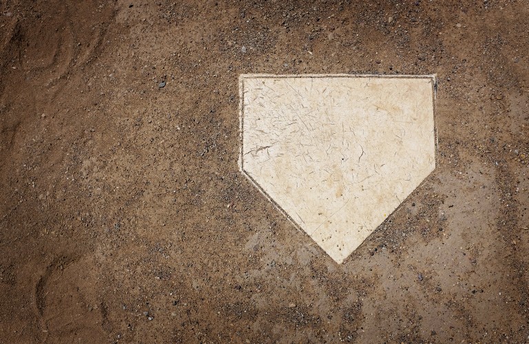 A home plate inside the dirt on a baseball diamond.