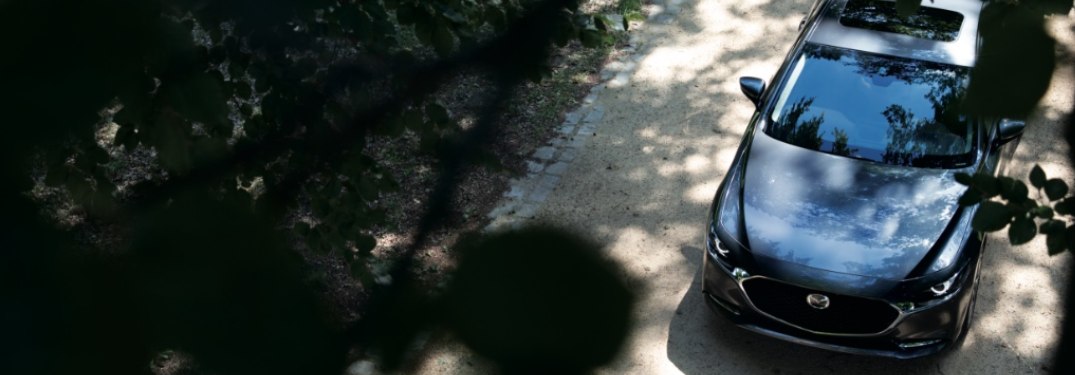 2021 Mazda3 Sedan driving down a rural trail