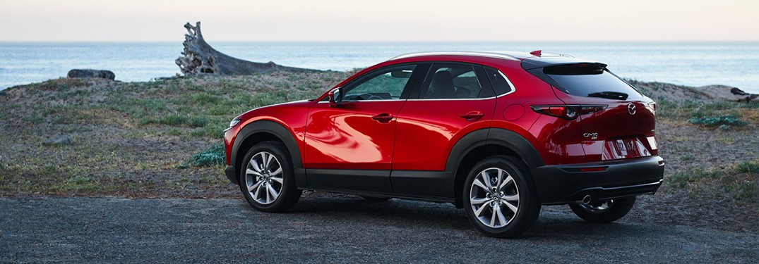 2021 Mazda CX-30 red parked by lake and grass hill