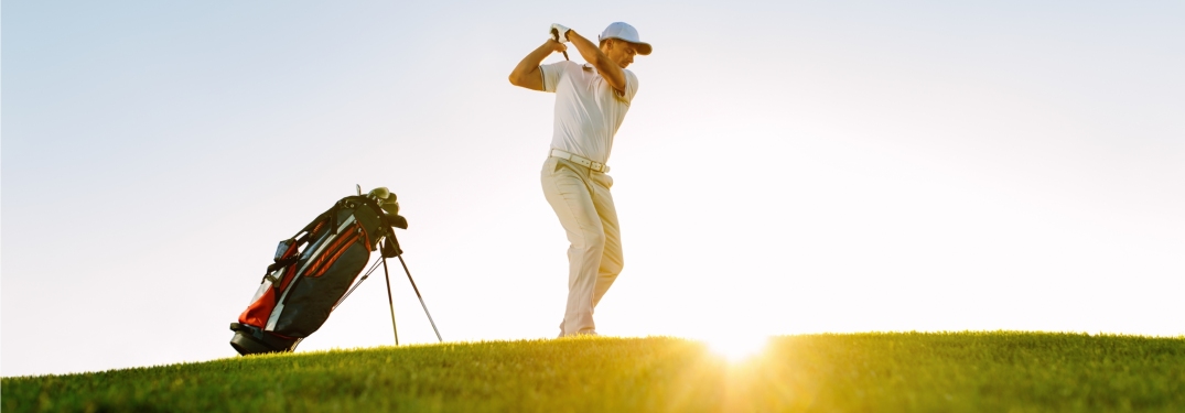 man driving a ball down a golf course