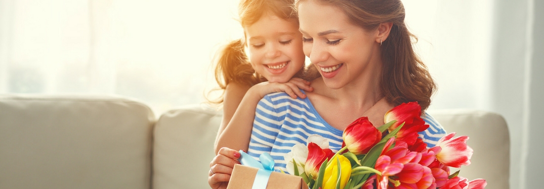 mom and daughter with flowers and gifts on mother's day