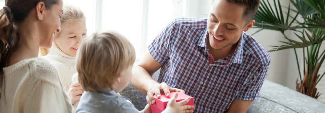 father receiving gifts from small child with wife