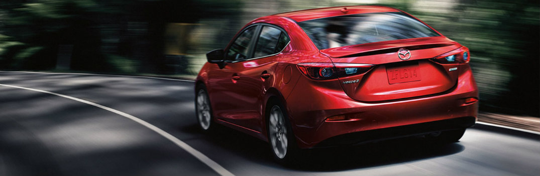 2018 Mazda3 driving on road surrounded by forest trees